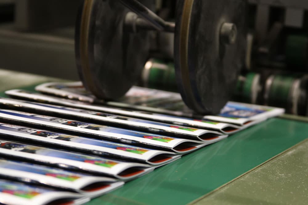 Saddle stitch binding: booklets coming off of our saddle stitcher